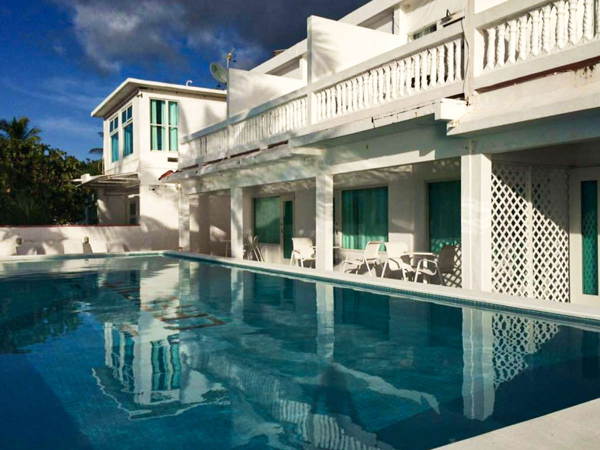 View of the white exterior of the accommodation with balconies overlooking the pool area
