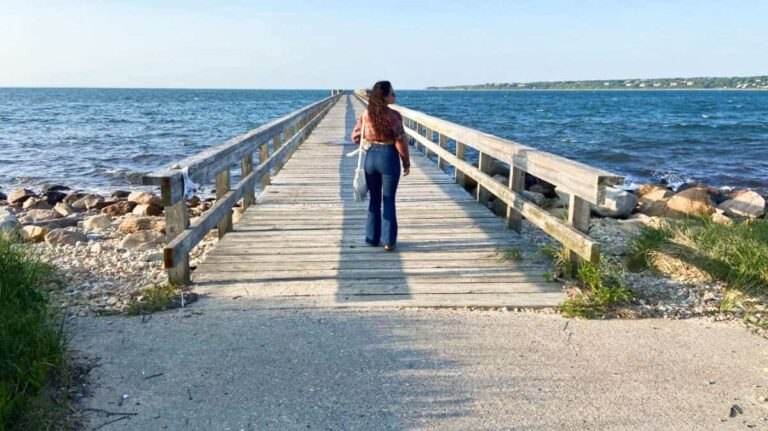 The author McKenna Mobley posing at the ocean boardwalk along the Paumanok Path by the Montauk Dog Park