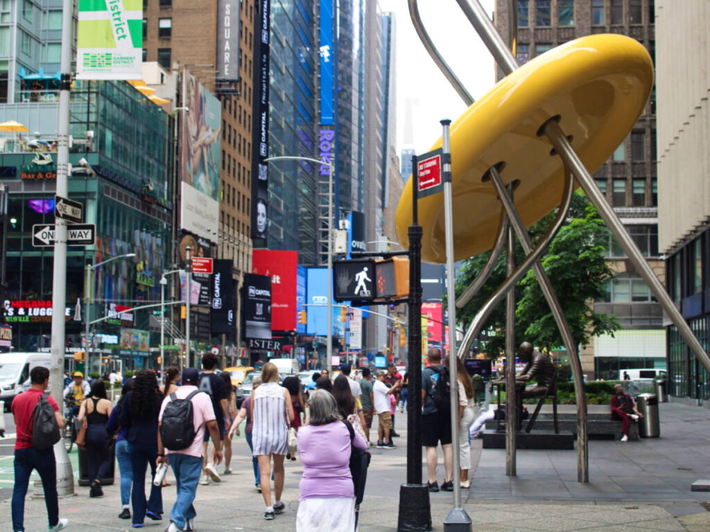 Crowd walking past the odd sculptures in Manhattan