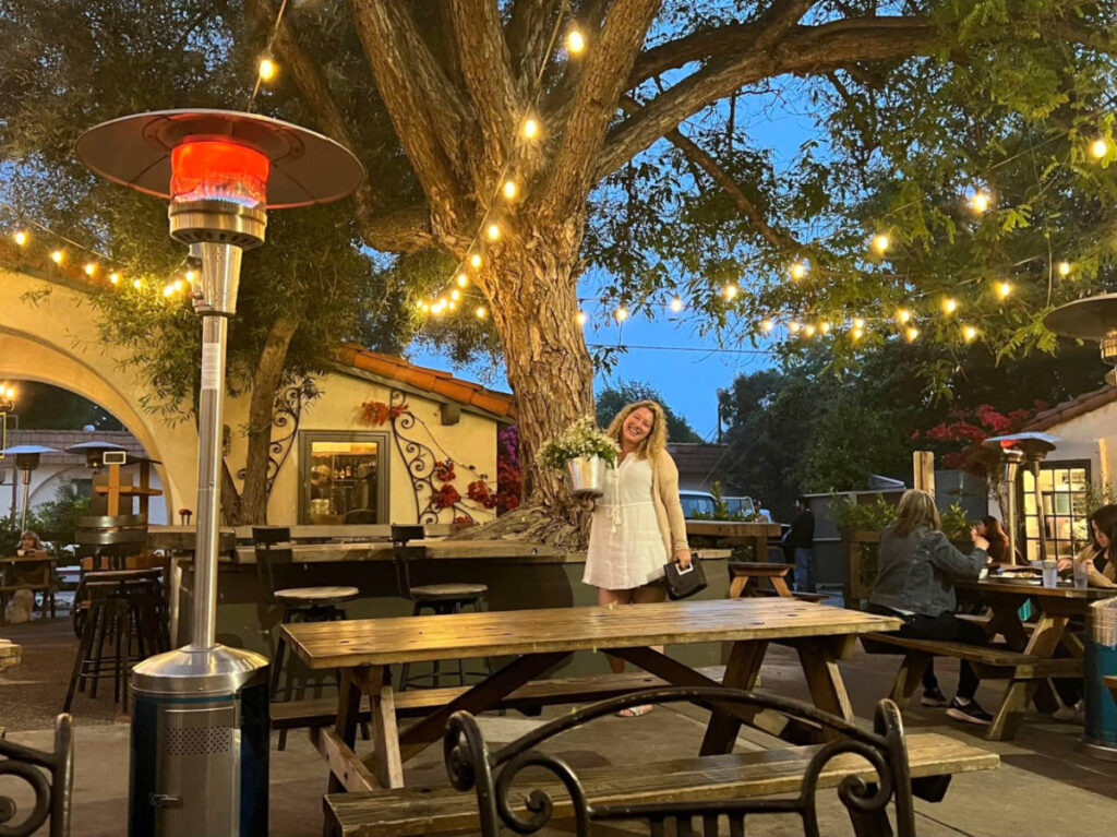 Jess Levy holding a pot of flowers at the outdoor patio of Ojai Rotie