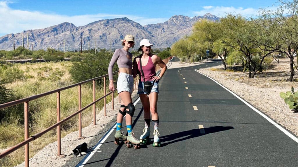 The author Betty Hurd and her friend wearing roller skates along the road of a neighborhood