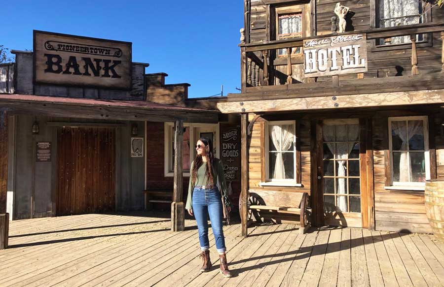 The author posing for a photo in front of old buildings in Pioneertown