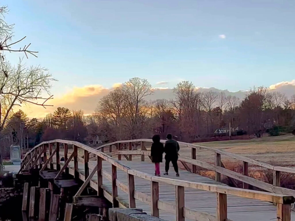 A couple crossing the Old North Bridge in Concord