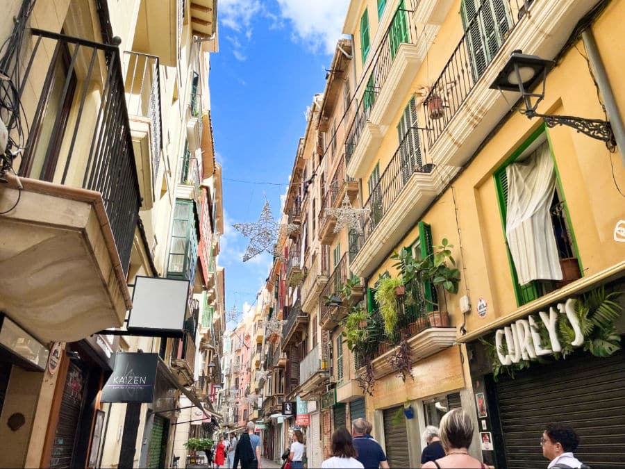 An alley of colorful tall buildings of shops in Old Town Palma