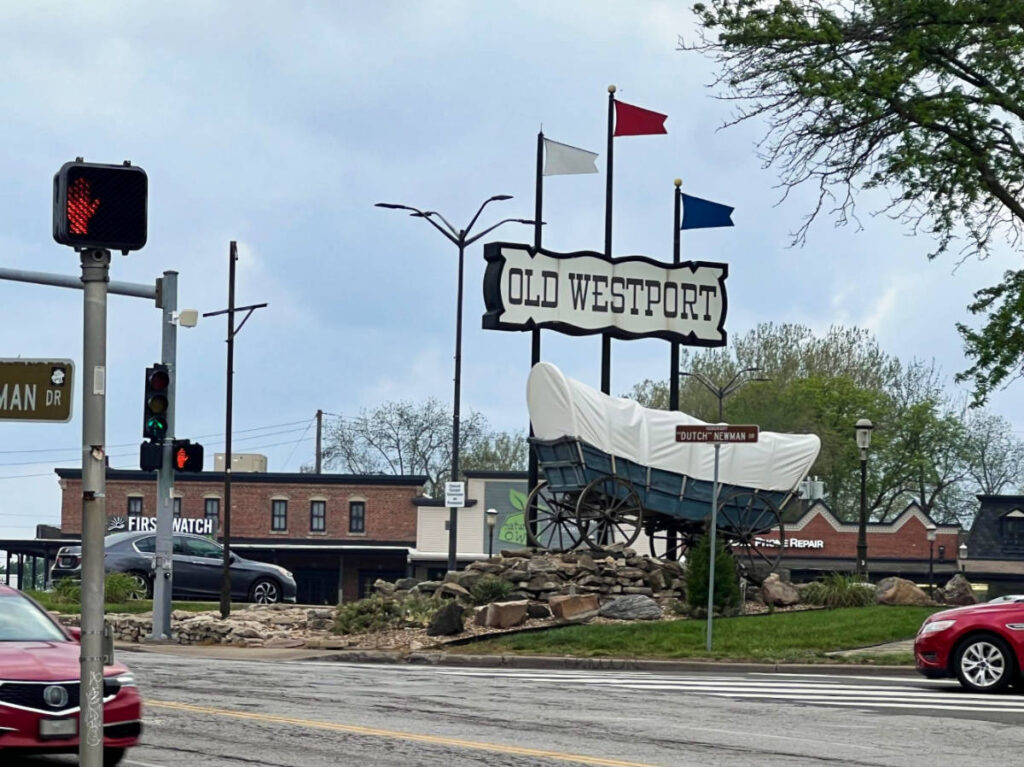 View of the Old Westport sign and covered wagon along the road