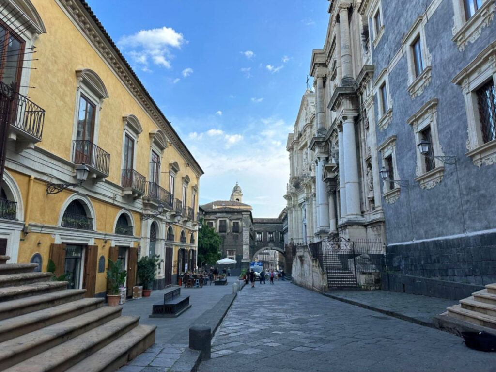 View of a narrow street in Via Crociferi, featuring old buildings