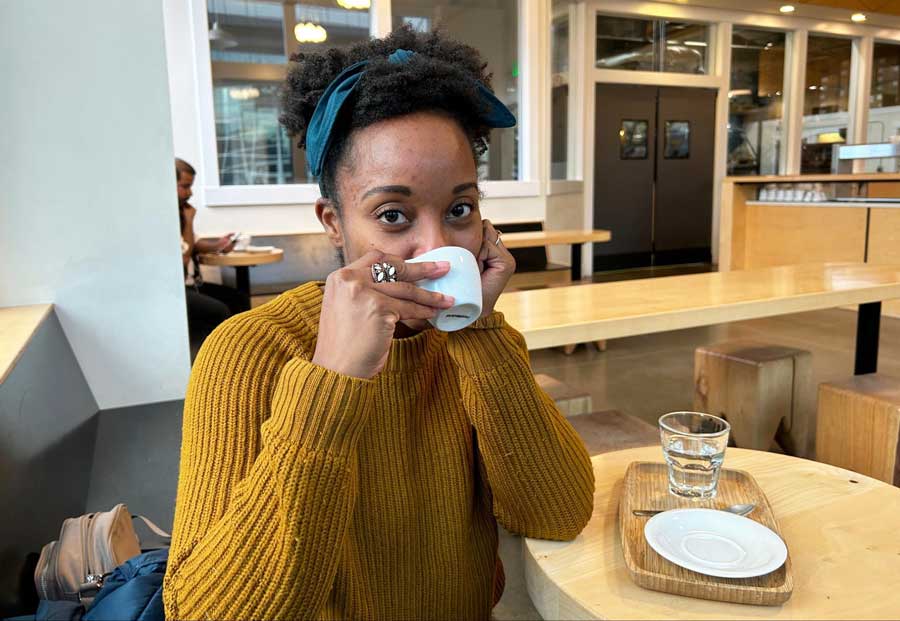 Author Chelsea sipping on her cup of espresso in Olympia Coffee Roasters