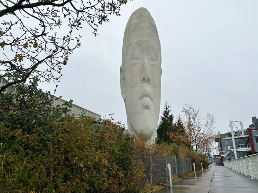 A massive sculpture of a man's face in Olympic Sculpture Park on a gloomy day