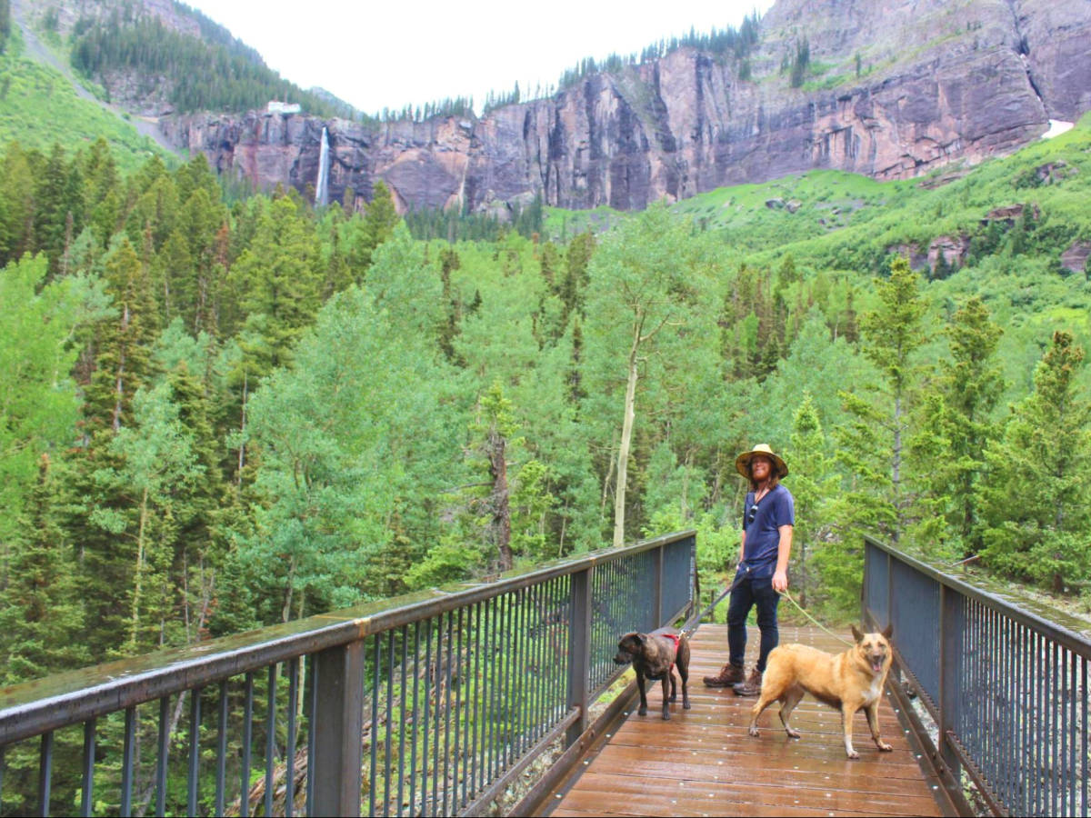 Editor Abigail’s husband and pups backdropped by the Bridal Veil Falls