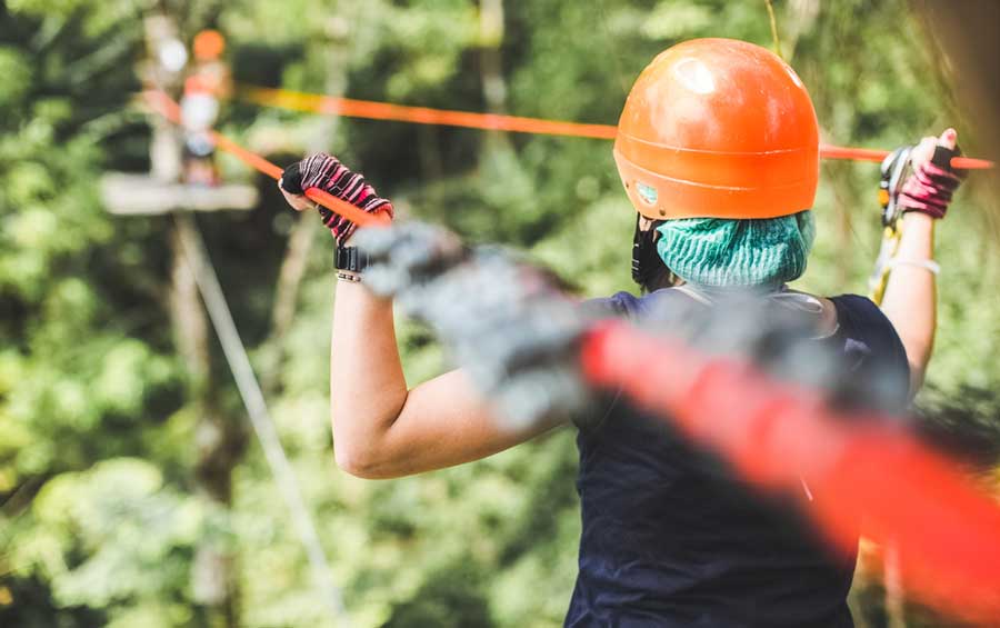 A woman holding on a rope in Open Air Adventure Park