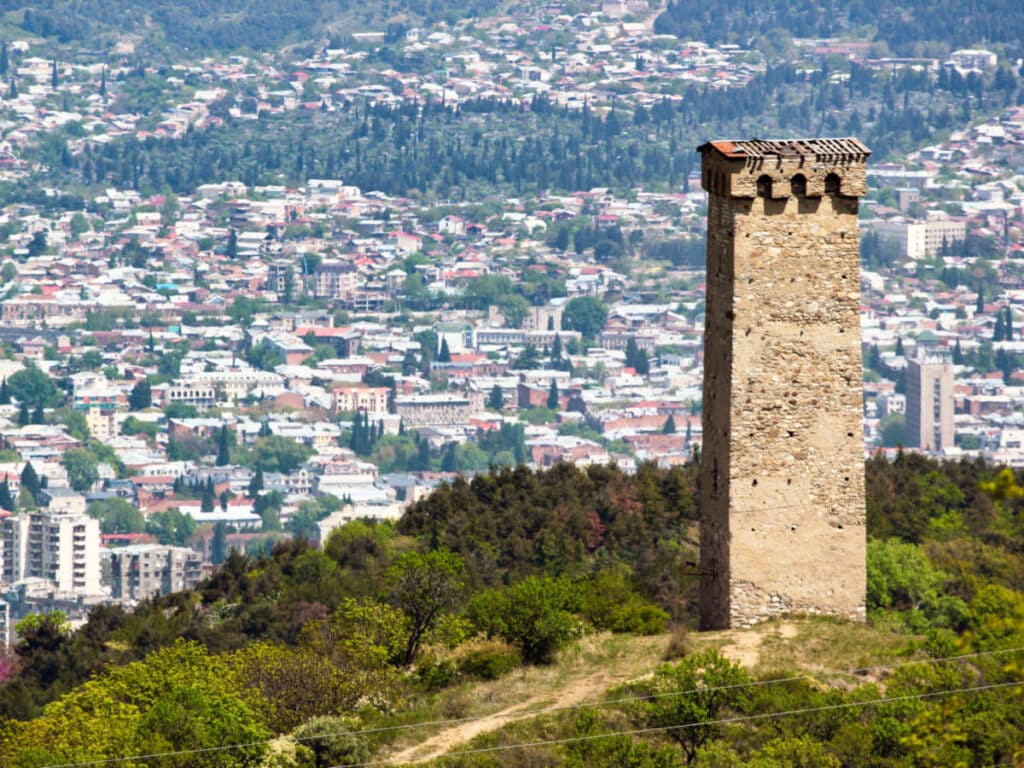 View of the Svaneti tower at the top of the mountain with an overlooking view of Tbilisi cityscape