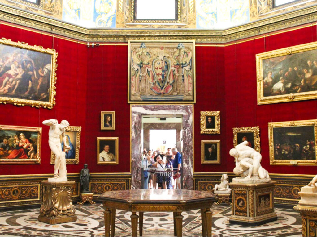 Interior view of the lavish museum with gold framed paintings and statues in Firenze 