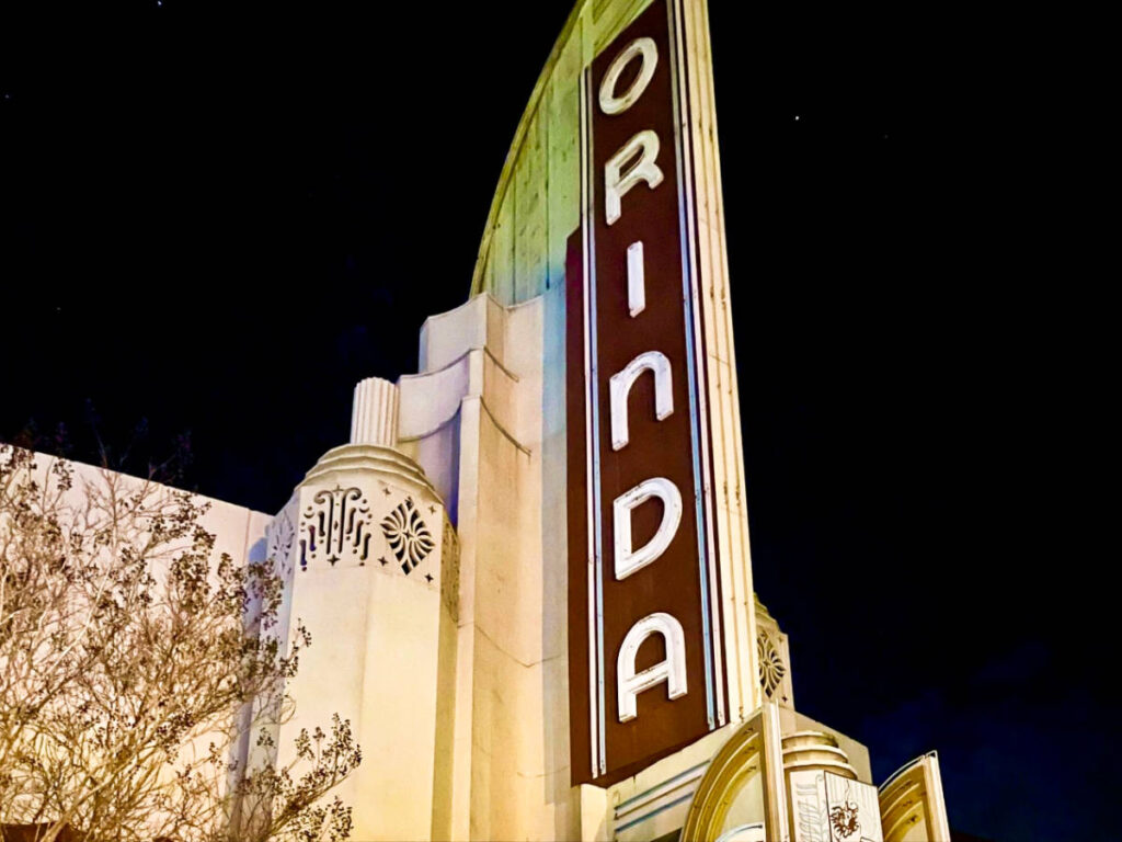 A sign of Orinda outside the historic movie theater at night