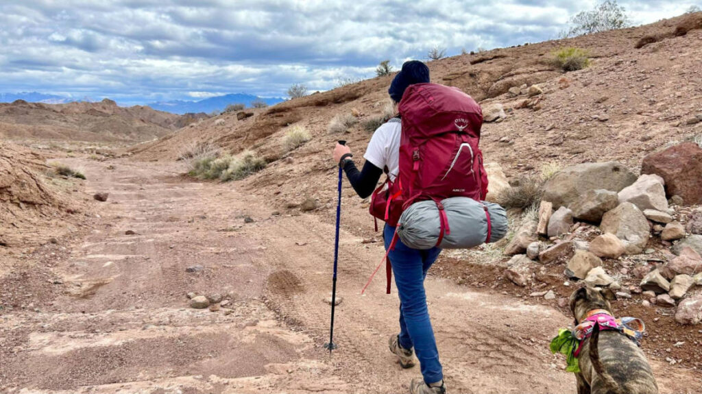 Skycie with her dog on a hike while using the Osprey Aura AG LT backpack
