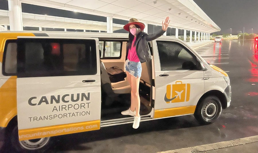 The author Nate Hake's partner posing by the door of Cancun Airport Transportation service
