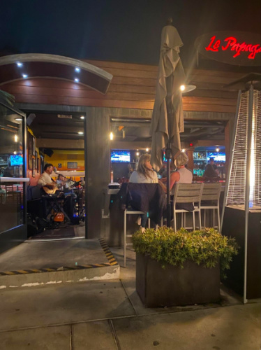 Outside view of Le Papagayo where customers is at the outdoor patio enjoying the live band