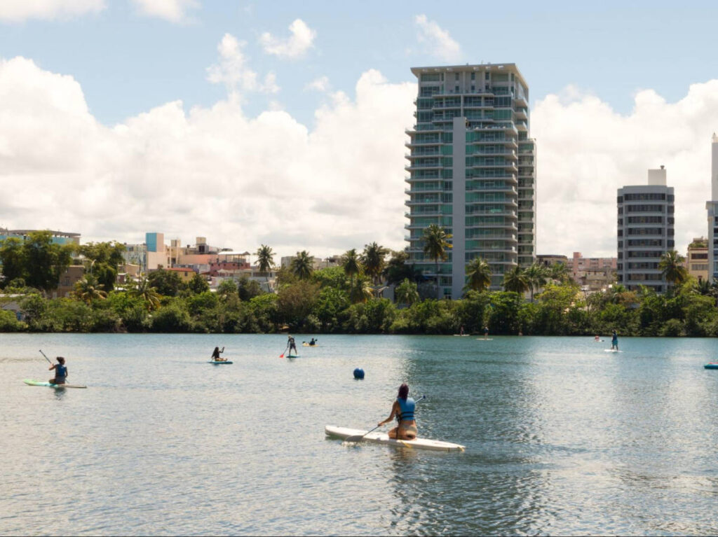 People paddleboarding in Condado’s lagoon with skyline view