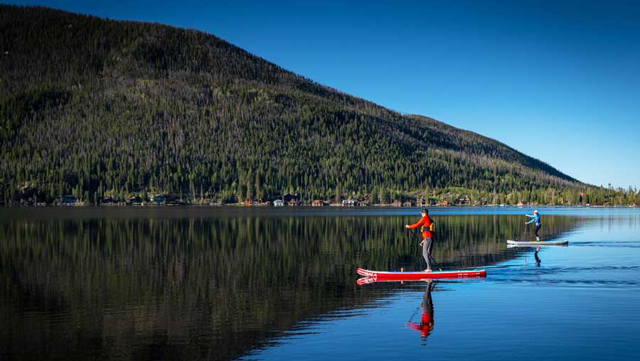 People paddleboarding on the lake of Grand Lake