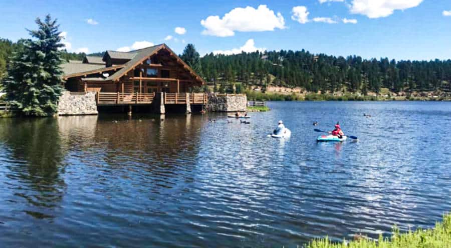 View of the people paddling on the water near a cabin in Evergreen Lake