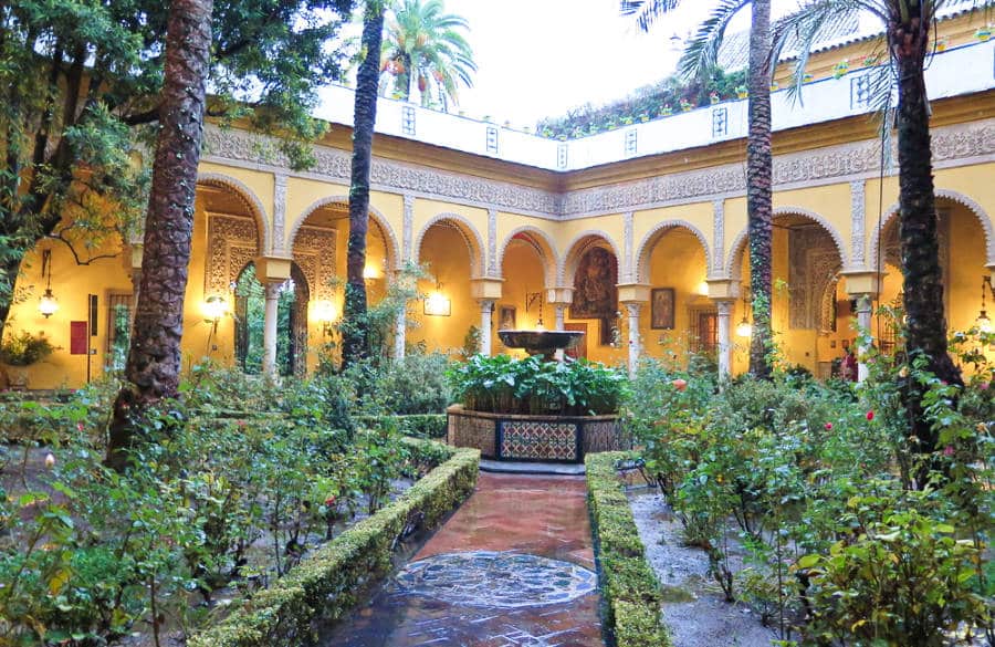 View of a pathway leading to the fountain in the middle of the courtyard of Palacio de las Dueñas