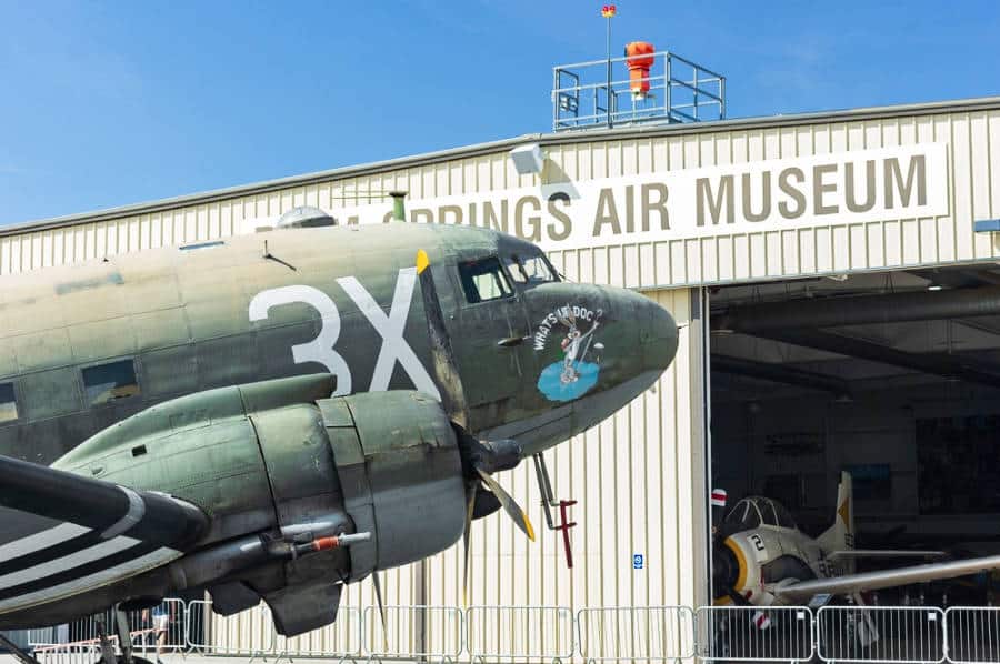 A military transport plane is shown outside the Palm Springs Air Museum.