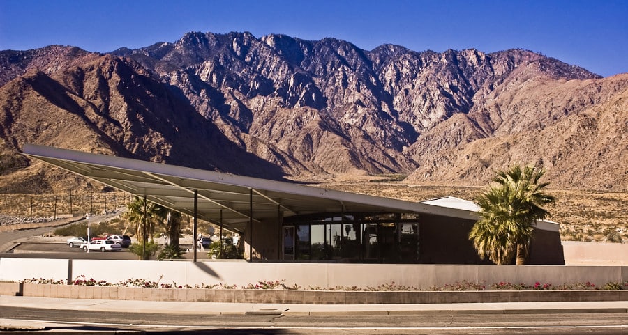 A modern architectural design of Palm Springs Visitor Center with the San Jacinto mountains in the background.