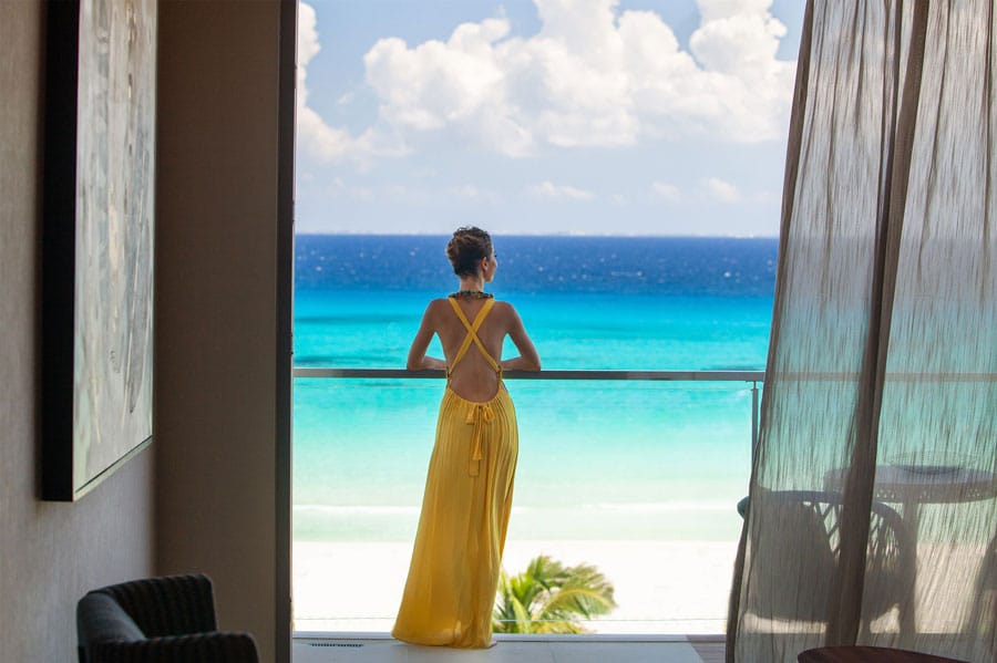 View of a woman admiring the view of the beach on Palmaïa Hotel
