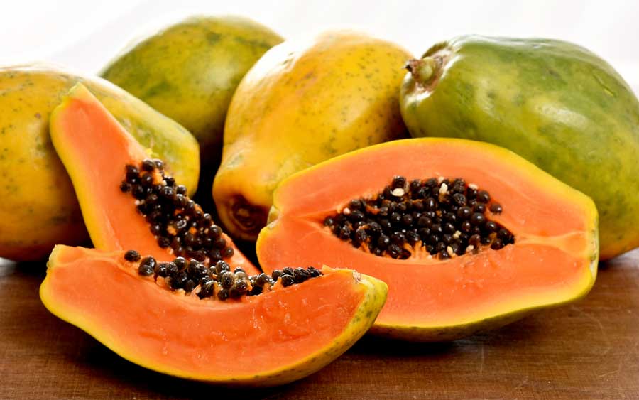 View of sliced papayas and whole papayas