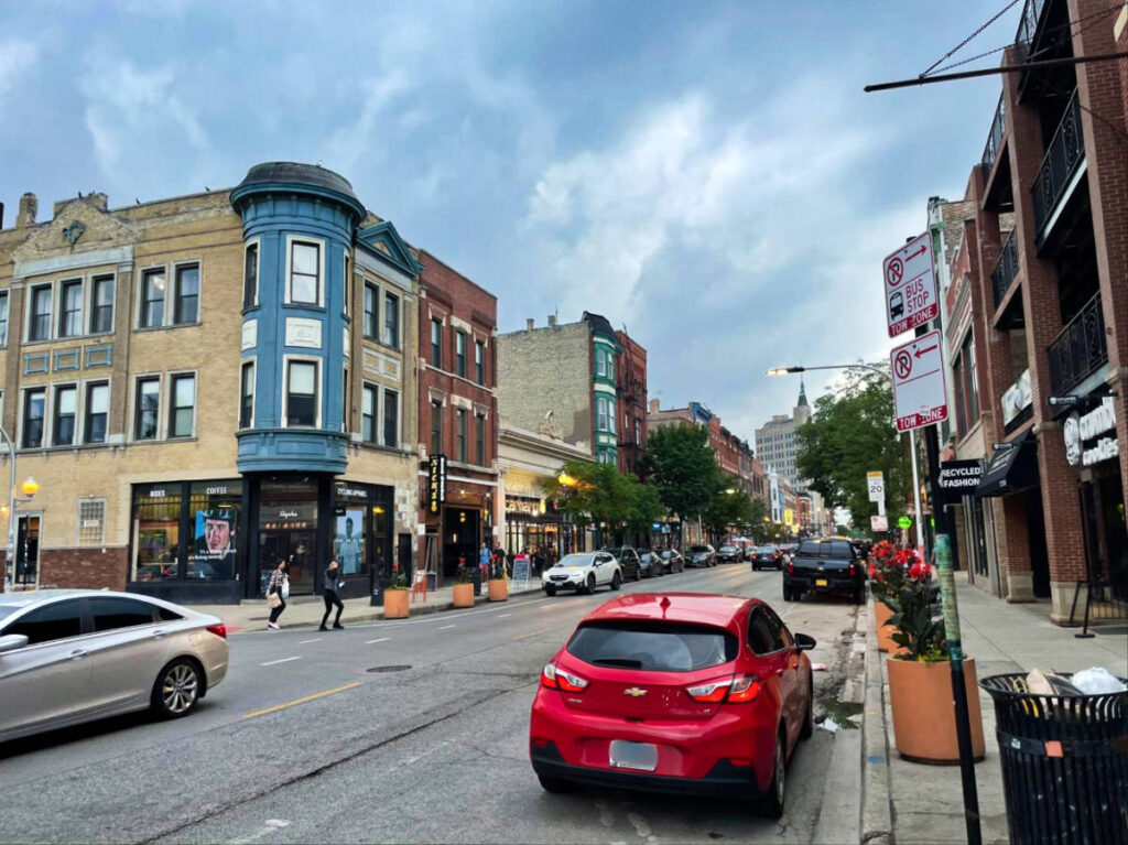 The cars parallel parked on the side of the streets in Chicago