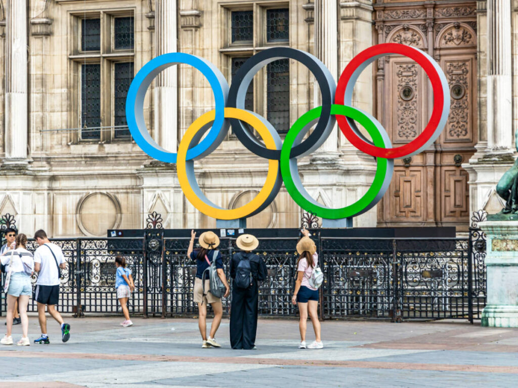 The tourists in front of the huge Olympics logo in Paris