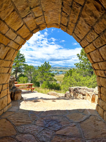 A stone arch with an overlooking view of the Guernsey Reservoir
