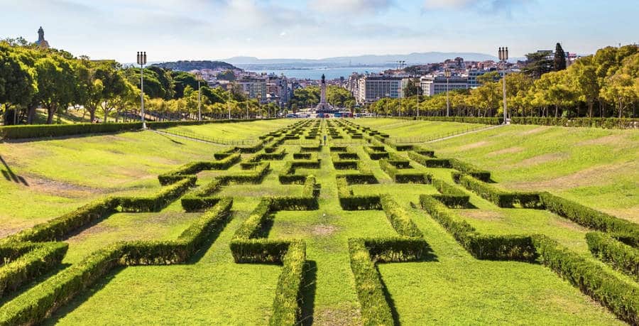 Picturesque view of the well maintained lined trees and a cityscape view from a distance at the Parque Eduardo VII in Lisbon