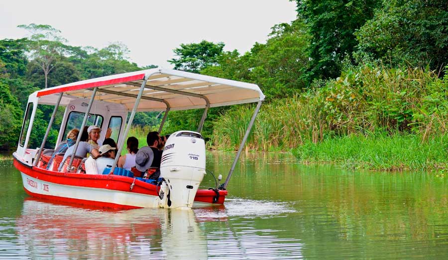 People on a tour riding a boat on the Tortuguero’s canals