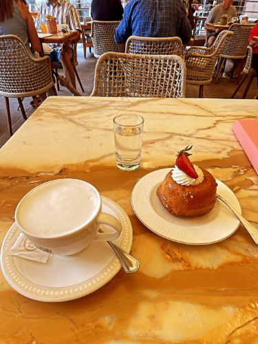A plate with Baba pastry and a cup of cappuccino