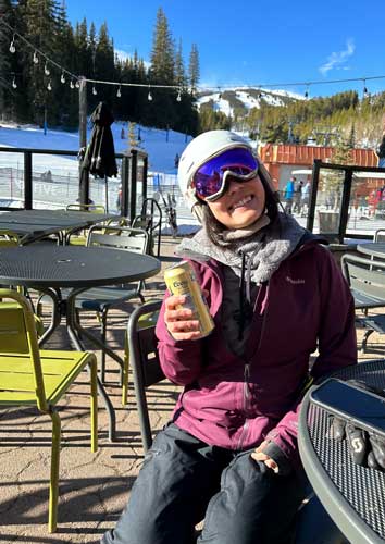 The author holding a Coors canned beer while resting in Peak 9 base area