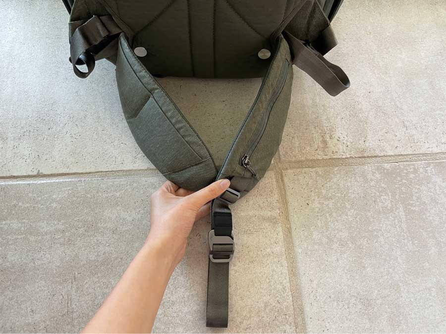 The author holding the waist straps of the Peak Design Travel Backpack