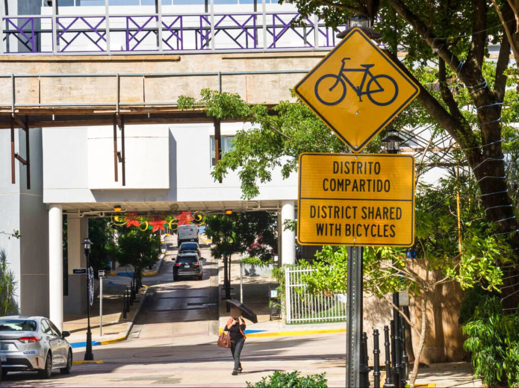 A pedestrian crossing the street in Bayamon on a sunny day