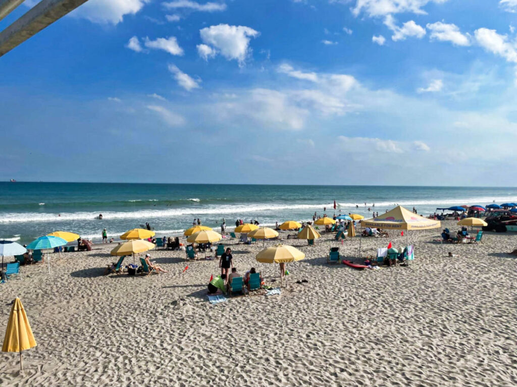 View of the people chilling along the shoreline at Cocoa Beach Pier