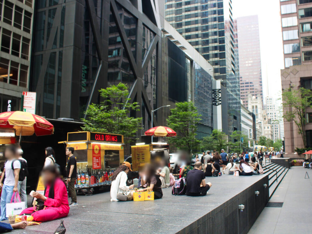 The people eating in front of The Halal Guys street food cart