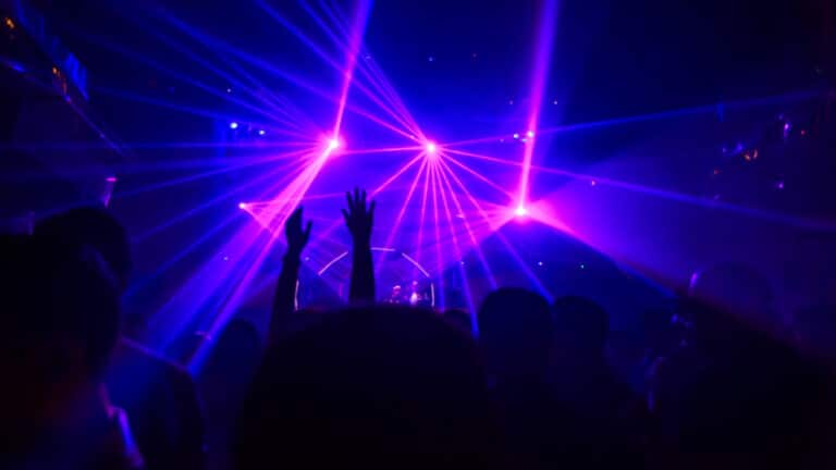 DJ playing from afar and people partying with the bright lights inside one of the best clubs in Vegas