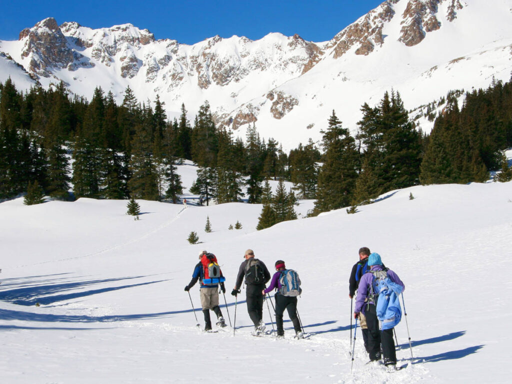 Scenic view of the people snowshoeing with snow covered mountain views