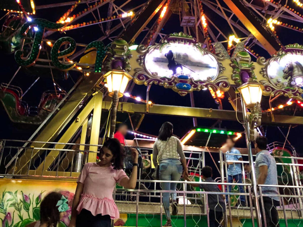 People at the ferris wheel at night