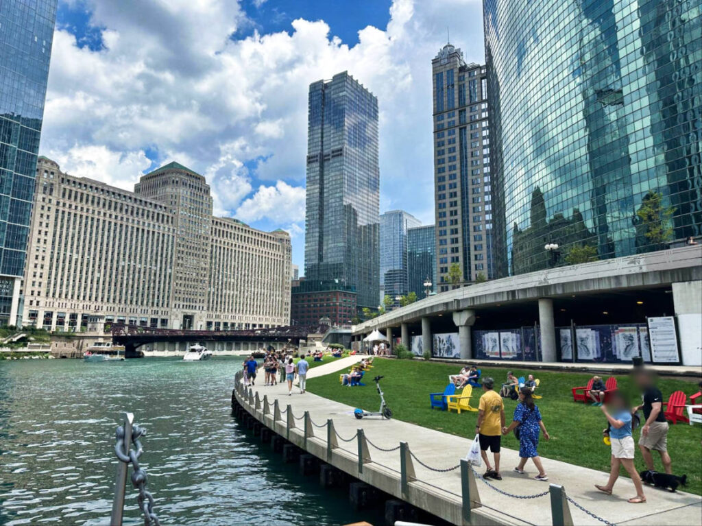 View of the people walking along the Chicago Riverwalk with the tall buildings around