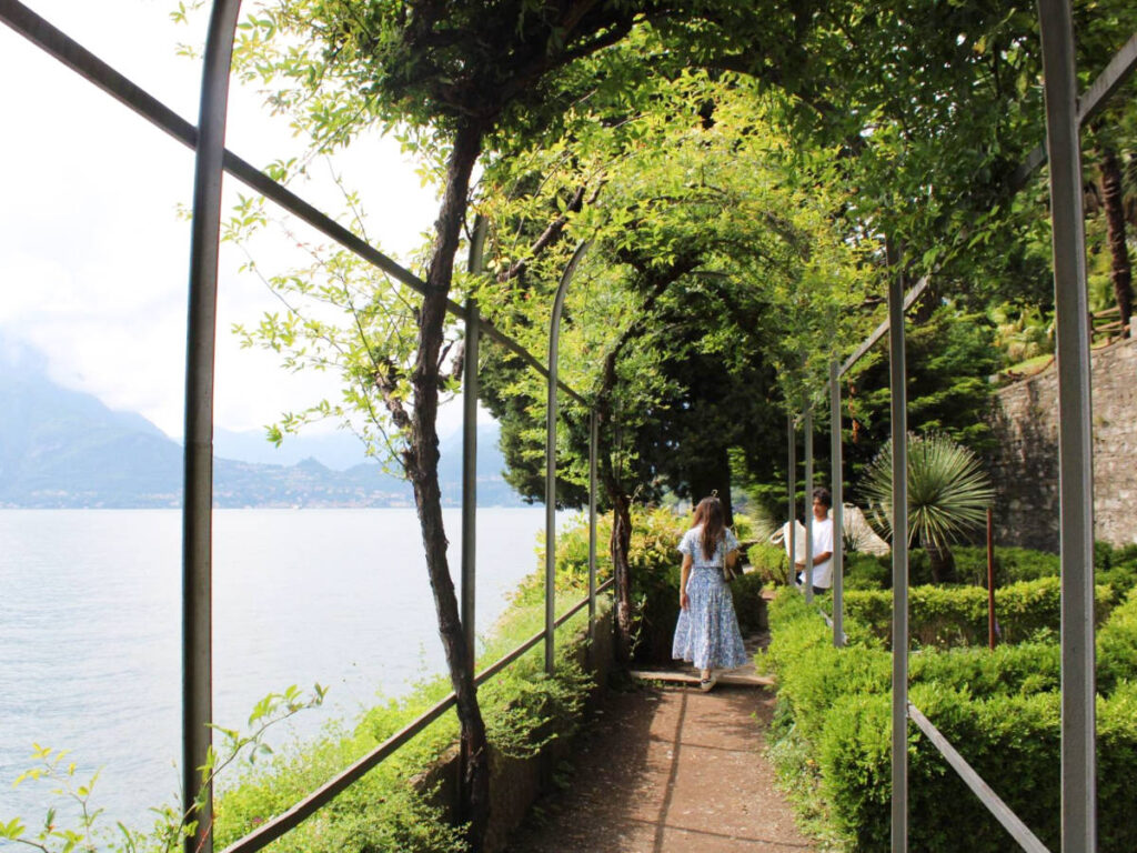 People walking at the arches surrounded by greenery in Lake Como