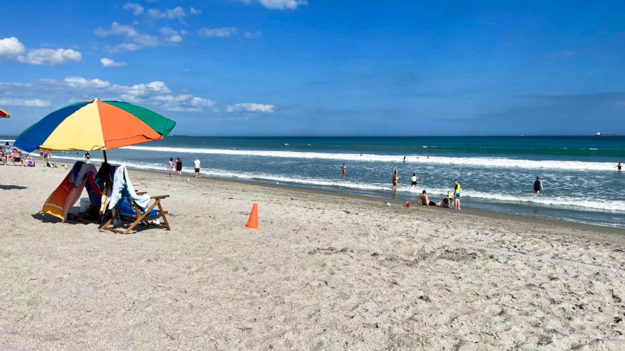Beach chairs with umbrella and people enjoying along the shoreline of Shepard Park