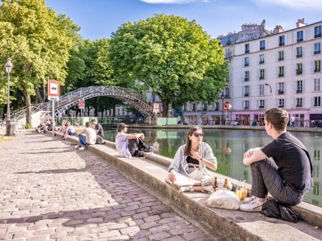 View of the people chilling at the Canal Saint-Martin on a sunny day