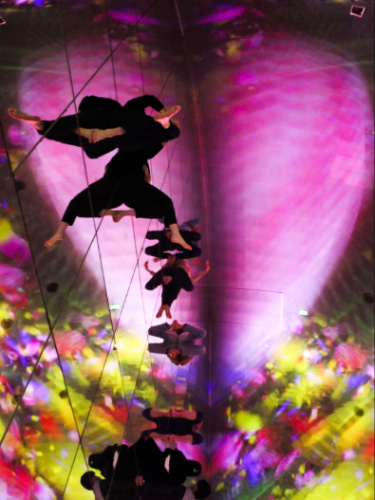 People relaxing under the colorful lights at teamLab Planets Tokyo