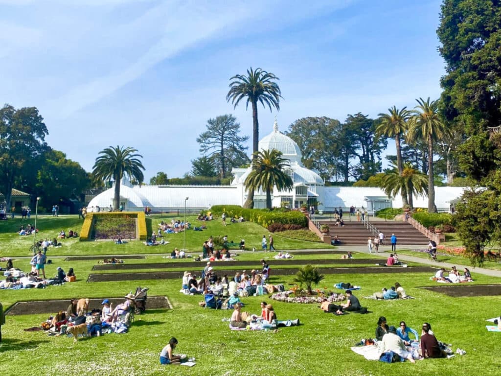 View of the people lounging in front of the Conservatory of Flowers in Golden Gate Park on a sunny day