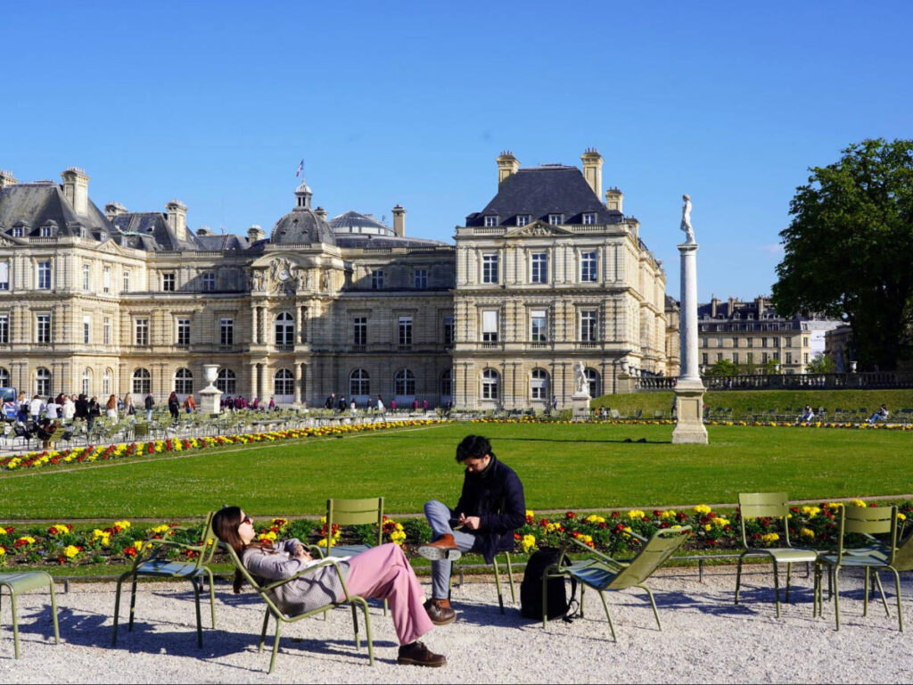 People relaxing during a sunny day in Luxembourg Gardens