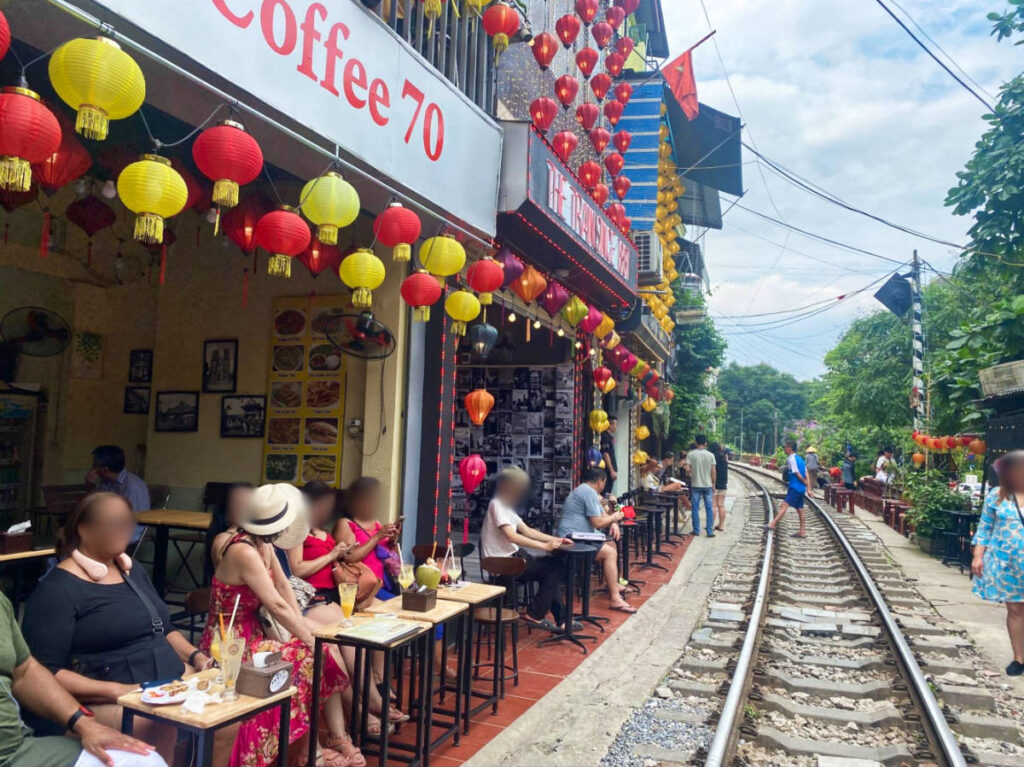 Tourists sitting at the coffee shops in the Train Street of Hanoi